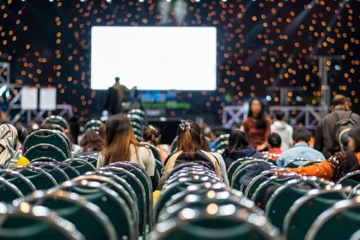 Público em evento com apresentação no palco